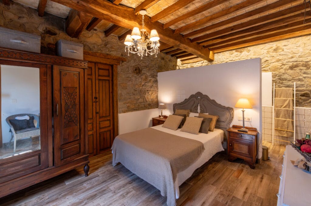 Dormitorio principal de La Casina de Gallegos con paredes de piedra y madera